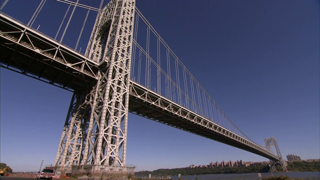 一辆交通部的SUV驶过纽约市的一座吊桥。视频素材