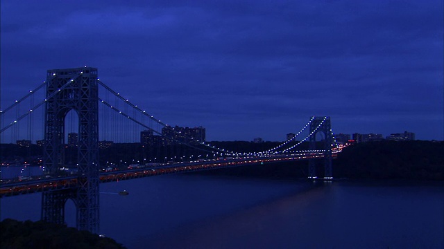 在纽约市，车辆穿过一座闪烁着灯光的大桥。视频素材
