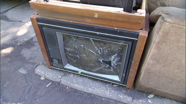 洪水过后，郊区一户人家门前堆满了破旧的电视机和其他家具。视频下载