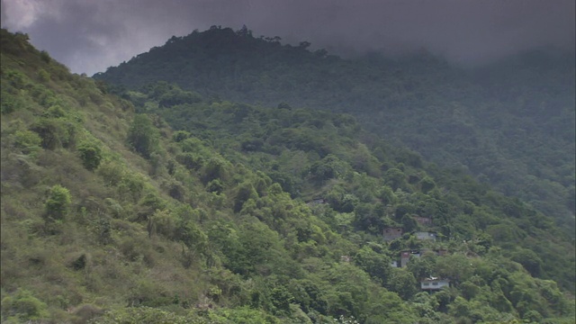 乌云笼罩着委内瑞拉的山脉和一个小山村。视频下载
