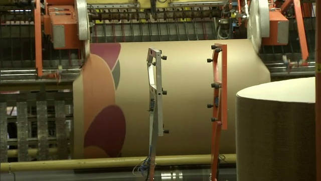 一台机器人将一大卷纸包裹起来。视频下载
