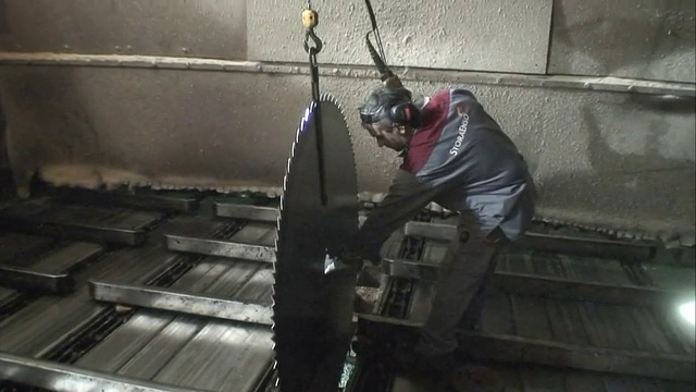 机械师在轧机中将锯条移动到合适的位置。视频下载