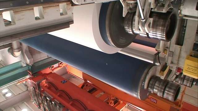 造纸厂的机器上，当轮子转动时，一个蓝色的圆筒升起。视频下载