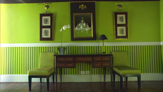 绿色的墙壁、绿色的椅子和优雅的艺术品装饰着酒店的走廊。视频下载