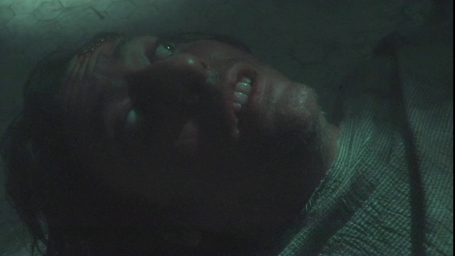 一个囚犯躺在一个坑的地上，惊恐地环顾四周。视频下载