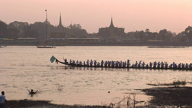 柬埔寨湄公河上，一艘长舢板驶过寺庙。视频素材