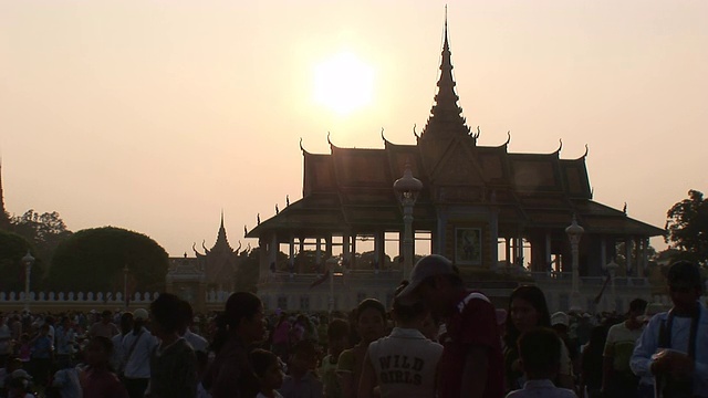 日落时分，一群人在柬埔寨一座寺庙周围散步。视频素材