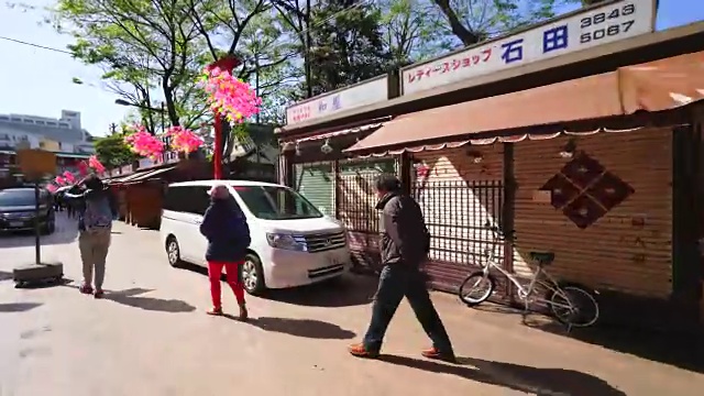 TL行走摄影机正穿过登角道。镜头捕捉到了街道两侧的许多传统日本礼品店和餐馆。视频素材