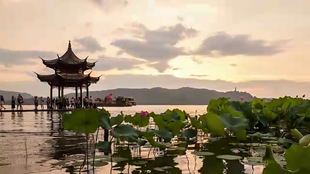 从白天到夜晚4K延时:日落时西湖上的亭子和荷花田，杭州，中国视频下载
