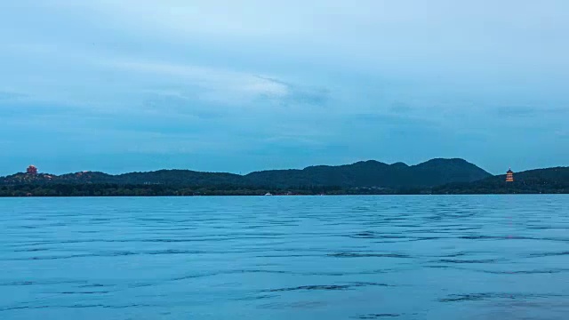 从白天到夜晚4K延时:照亮西湖上的城黄塔和雷峰塔，杭州，中国视频下载