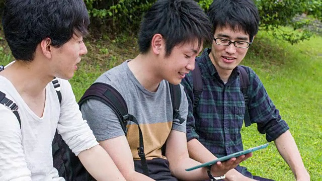 日本学生与一个数字平板电脑一起工作视频素材
