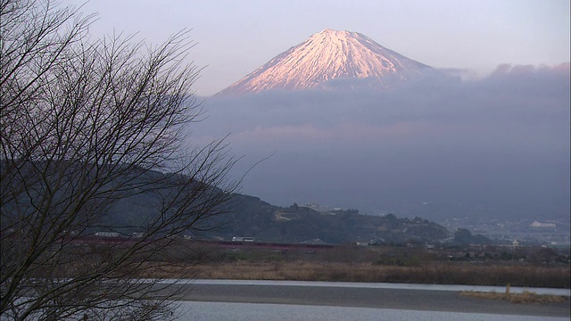 车辆经过远处若隐若现的富士山。视频素材
