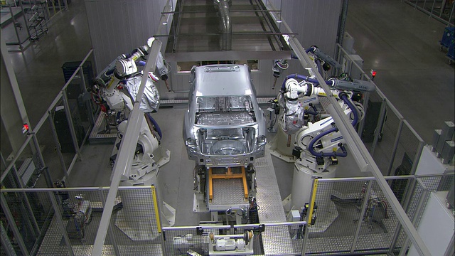 机器人位于一条汽车装配线的侧面。视频素材