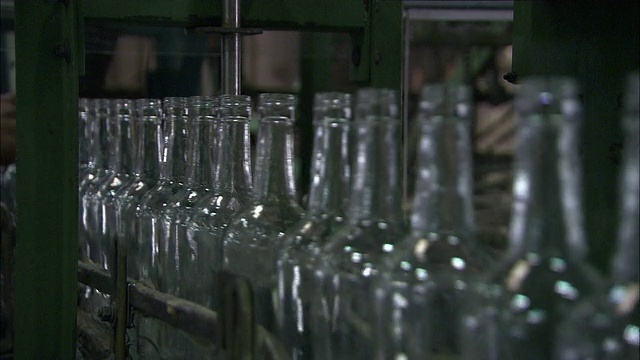 传送带在朗姆酒装瓶厂快速地传送干净的瓶子。视频下载