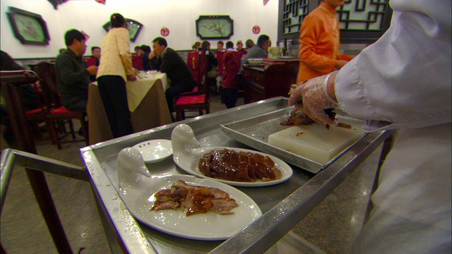 在中国餐馆里，厨师在准备几盘肉。视频下载