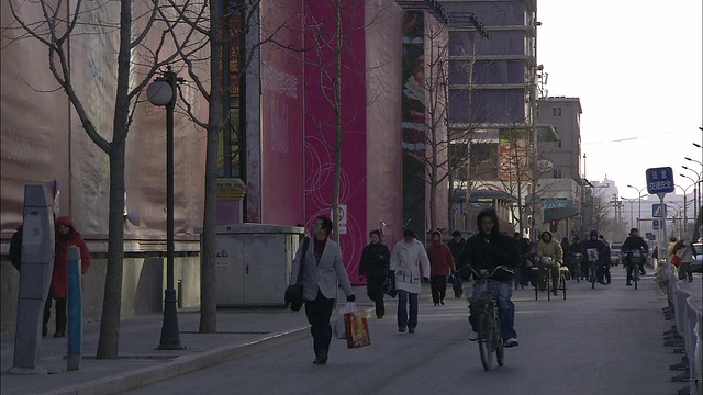行人和自行车在北京一条繁忙的街道上行走。视频素材