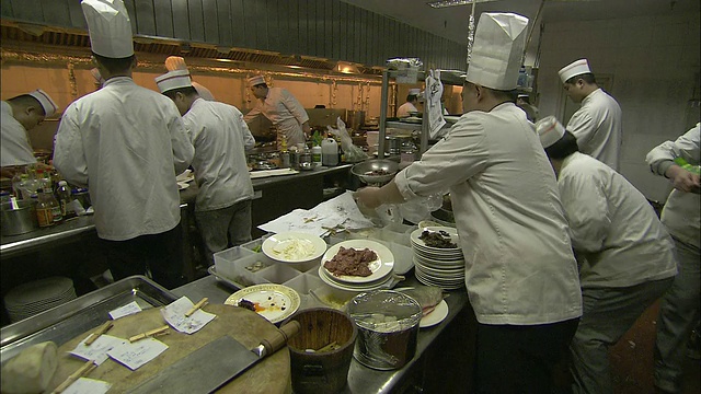 餐馆厨师在北京的一个大厨房里准备食物。视频素材
