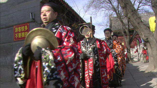 在中国北京的一个节日上，身着传统服装的男子在展示乐器。视频下载