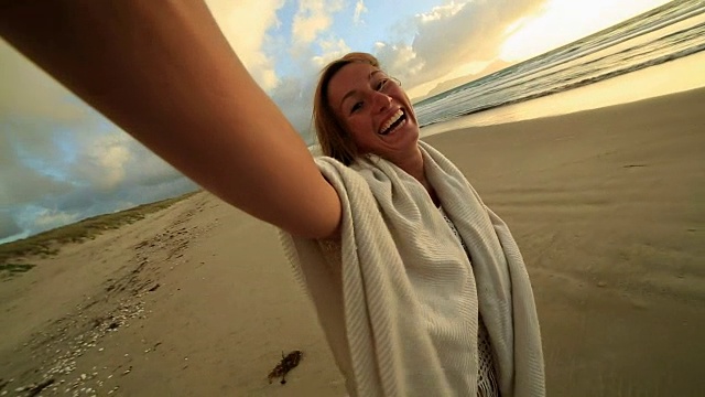 一个快乐的年轻女子在海滩上的自画像视频素材