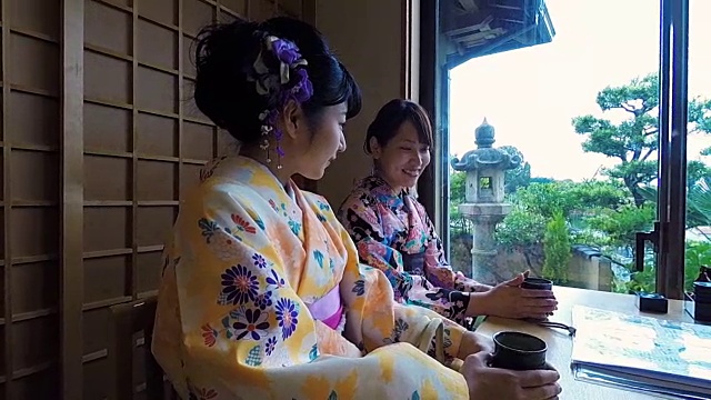 年轻的日本女性穿着传统和服喝茶视频素材