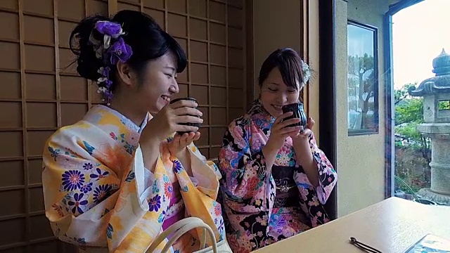 年轻的日本女性穿着传统和服喝茶视频素材