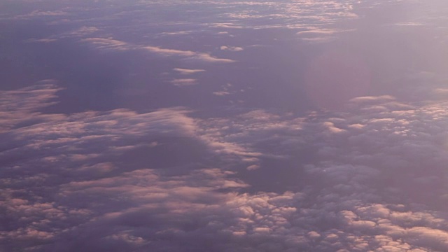 飞机窗外多云的日落景色。视频素材
