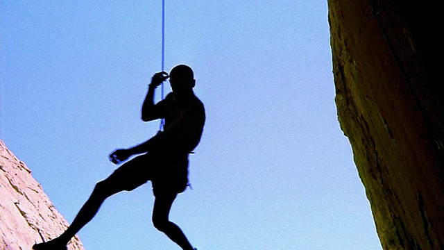 低角度向下倾斜的攀岩者，安全绳从倒置的岩面坠落+击中下面/内华达的岩壁视频下载