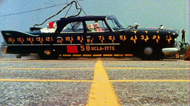 1968年慢镜头低角度广角拍摄两辆车与测试假人在碰撞测试中碰撞/其中一辆旋转向摄像机视频下载