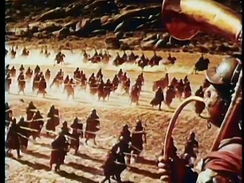 高角度广角PAN重现罗马士兵与盾牌+长矛在战场上奔跑/士兵吹喇叭在前景视频素材
