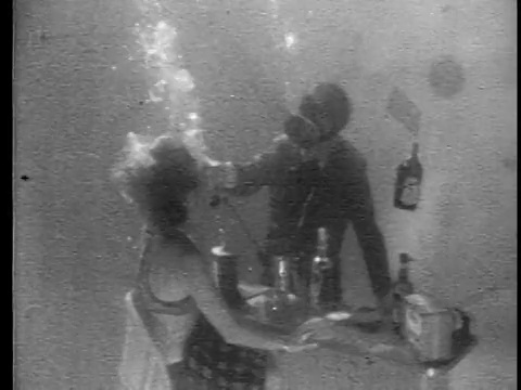 20世纪60年代颗粒水下男子在酒吧后面给坐在水下酒吧的女人打电话视频素材