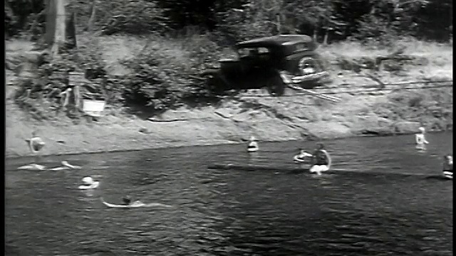 B/W 1932宽镜头汽车在悬挂电缆上倒车与游泳者/ Barlow, OR视频下载