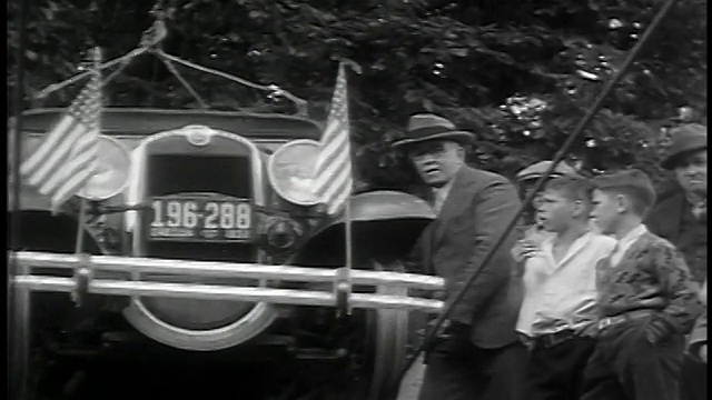 1932年低角度高级男子和男孩观看汽车悬索开始驾驶河/巴洛，或视频下载