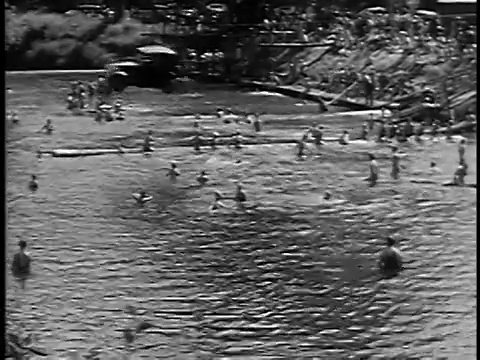 1932年宽镜头长镜头，人们从汽车上和游泳者在悬挂在河上的电缆上跳下来视频下载