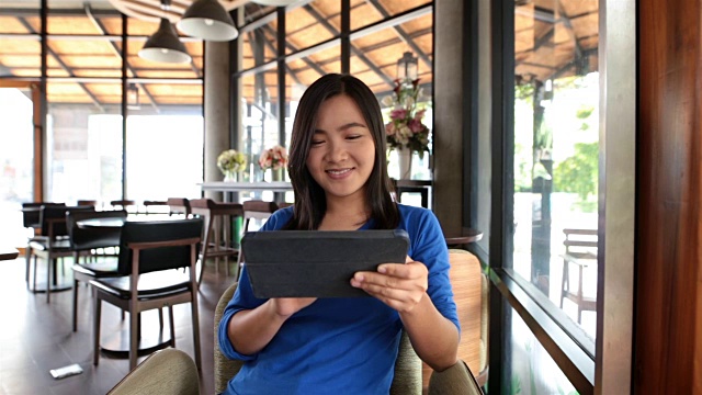 一个女人在咖啡馆里用平板电脑视频素材