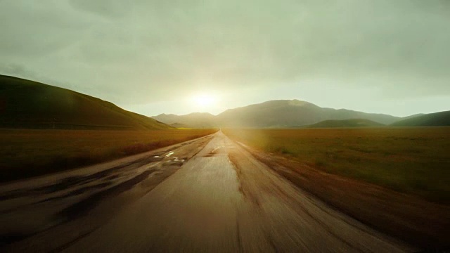 在日落时分开着车在一条笔直的路上行驶视频素材