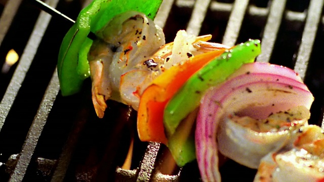 高角度近距离拍摄烤肉串与虾+蔬菜在火焰烧烤视频下载
