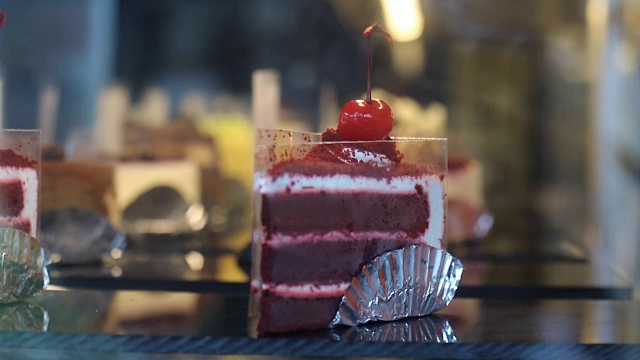 把新鲜的红丝绒纸杯蛋糕放入蛋糕陈列柜的冷冻机视频素材