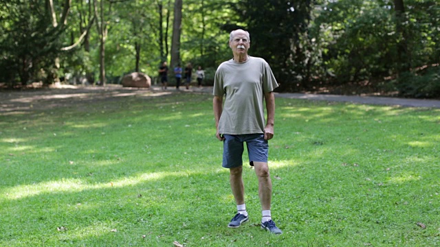 一个自信的老人站在公园里视频下载