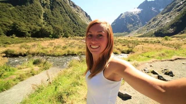 年轻女子在美丽的新西兰风景中自拍视频素材