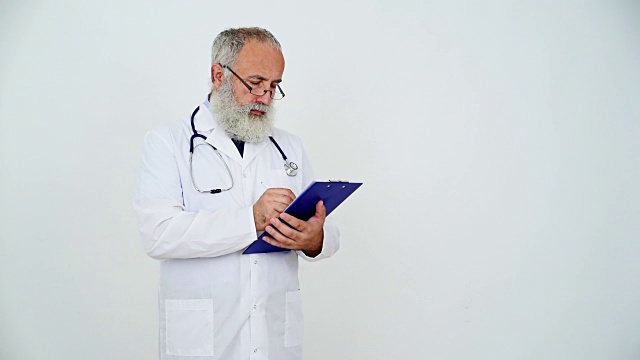 成年资深医生在灰色背景的剪贴板上写字视频素材