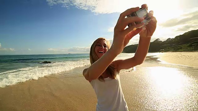 一名白人年轻女子在海滩上自拍视频素材