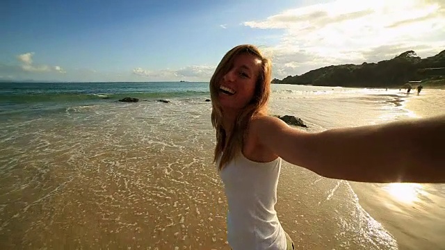 一名白人年轻女子在海滩上自拍视频素材