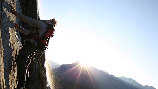 登山运动员攀登岩壁，日出视频素材