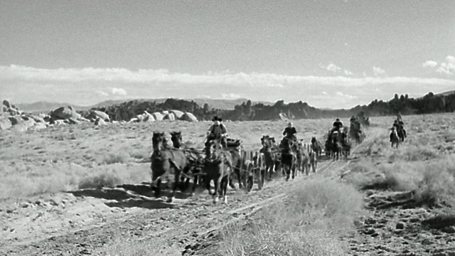 19世纪宽镜头的马车和马背上的人在沙漠中射击超速通过相机视频素材