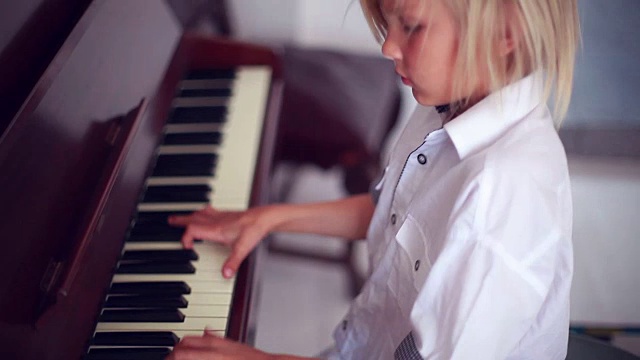 一个金发男孩在弹钢琴视频下载