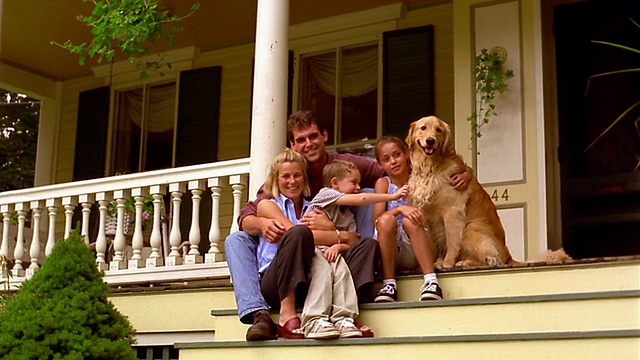 多莉拍摄的肖像家庭坐在金毛猎犬的门廊视频素材
