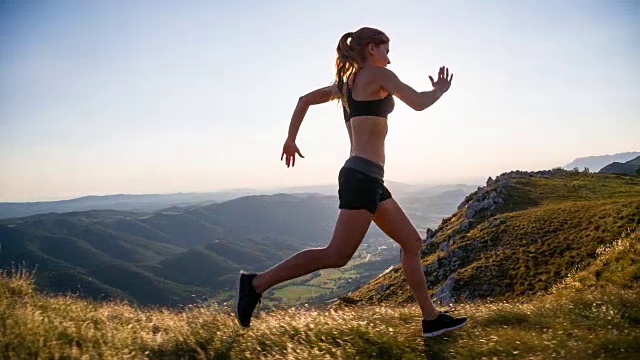 年轻的女运动员在山上跑步视频素材