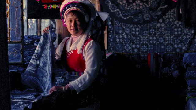 MS PORTRAIT白族妇女在传统服装折叠面料商店/大理，云南省，中国视频下载