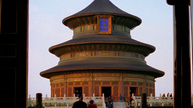 广角镜头三层圆形天坛，一对情侣在前景中行走/中国北京视频下载