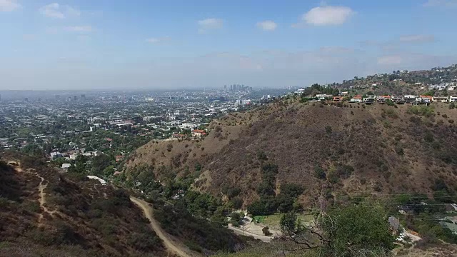 一名年轻女子站在洛杉矶附近的一座山上的4K航拍，4K胶片视频素材